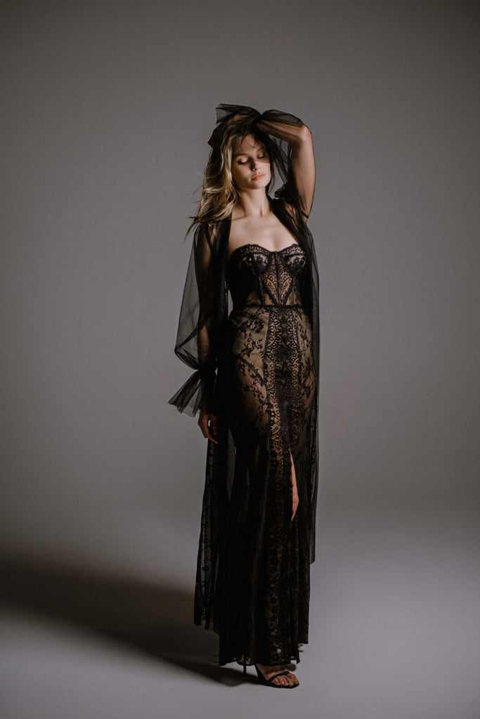 RAZIL is a dramatic and audacious evening gown. This corset dress is handcrafted in luscious black lace, boasting a modern geometric pattern. The classic dreamy silhouette is achieved thanks to the addition of a beautiful tulle robe. This bold gown dynamic and sexy, with playful sheer layers masterfully applied with elite craftsmanship.