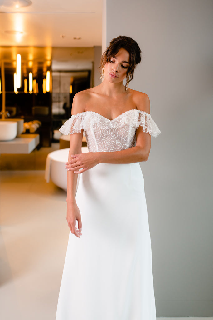 This two-piece bridal gown is a staple of femininity thanks to the unique embroidered corset, adorned with delicate beading and volant detail. Paired with a fitted chiffon skirt, ROSIE is a sure head-turner! You’ll feel superior in this elegant and feminine wedding dress.