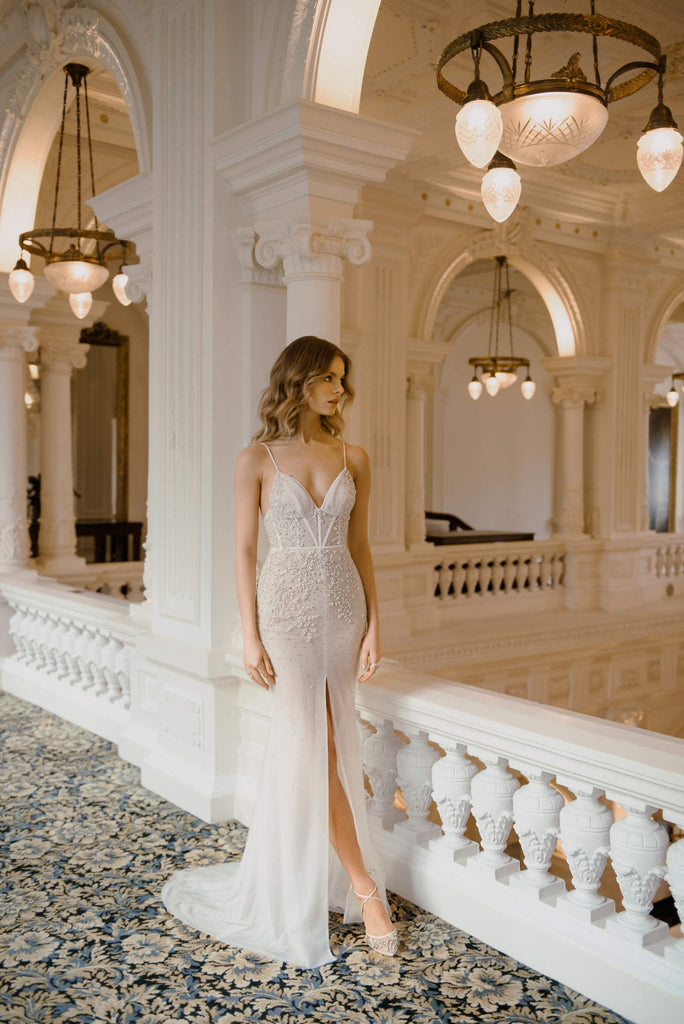 FLORENTINE is a sexy, figure-flattering Wedding Dress that is truly one of a kind. It’s crafted in gentle blush tulle and ravishes with luscious hand-embroidered lace, embellished with just the right amount of stones. This dress is paired with a stunning tulle robe, adorned with shimmering stones, giving the final look a hint of intrigue. 